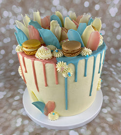 blue and pink drip birthday cake with macarons