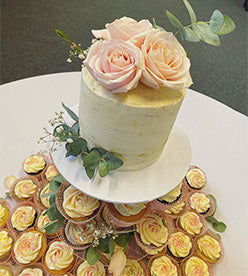single tier naked wedding cake with cupcake tower
